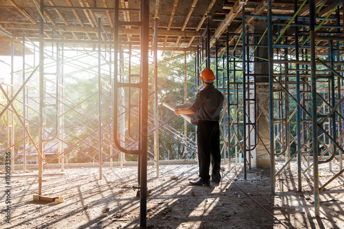 Engineer with blueprint in building construction site