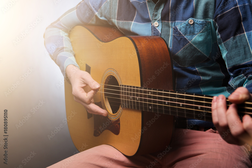 Fototapeta premium Musican with guitar in hand on dark background. Studio shot