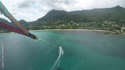 An adventurous couple parasailing at Beau Vallon Beach in Mah_, Seychelles. GoPro, extreme summer sports, POV.  onboard camera. , 1 of 3