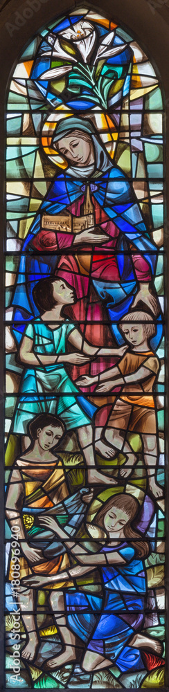 LONDON, GREAT BRITAIN - SEPTEMBER 19, 2017: The Virgin Mary and the children on the stained glass in chapel of St Mary Abbot's church on Kensington High Street  designed by Alfred R. Fisher (1966).