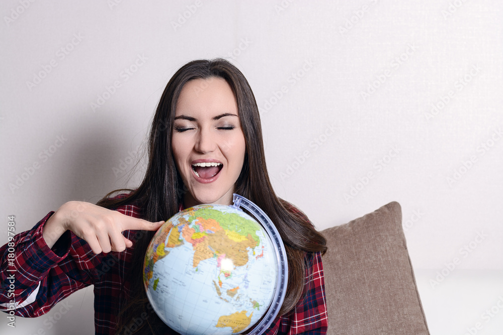Go on an adventure. Fun woman dreaming about traveling around the world, spinning a globe and pointing at random country. Happy cute brunette preparing for the journey Go on an adventure. Fun woman dreaming about traveling around the world, spinning a globe and pointing at random country. Happy cute brunette preparing for the journey