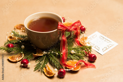 Cup of black tea, Christmas toys, gifts and decorations on craft background photo