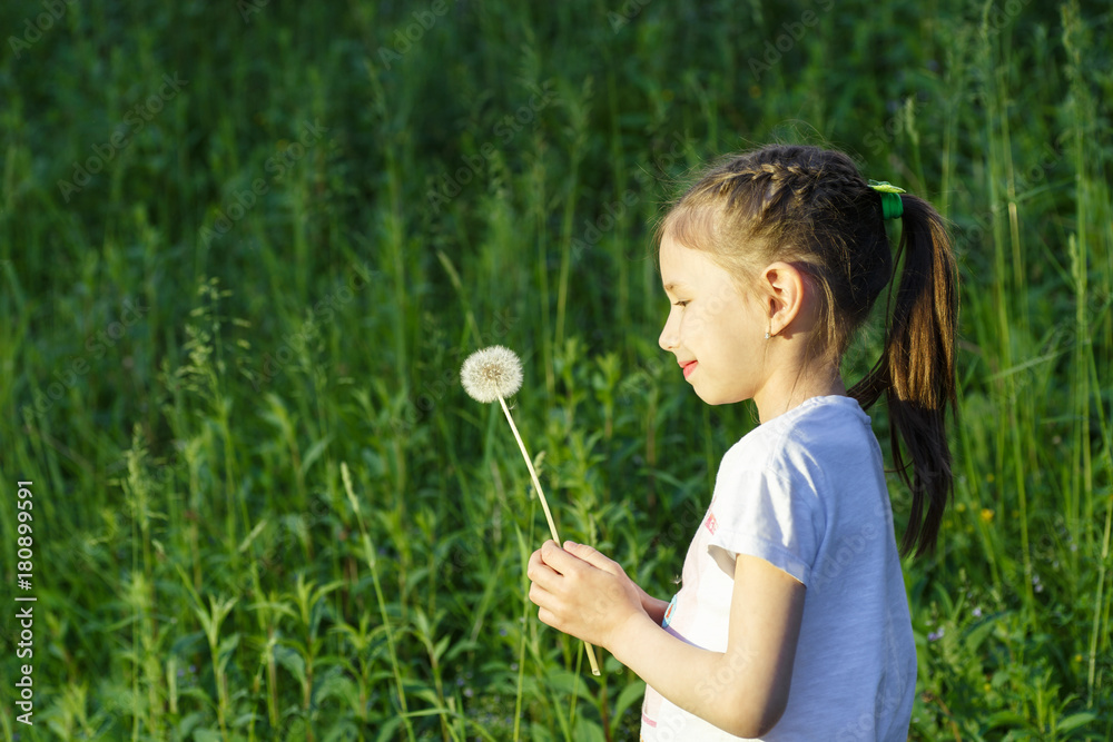 Beautiful child blowing away dandelion flower in spring. Fun on meadow. Beautiful child blowing away dandelion flower in spring. Fun on meadow.