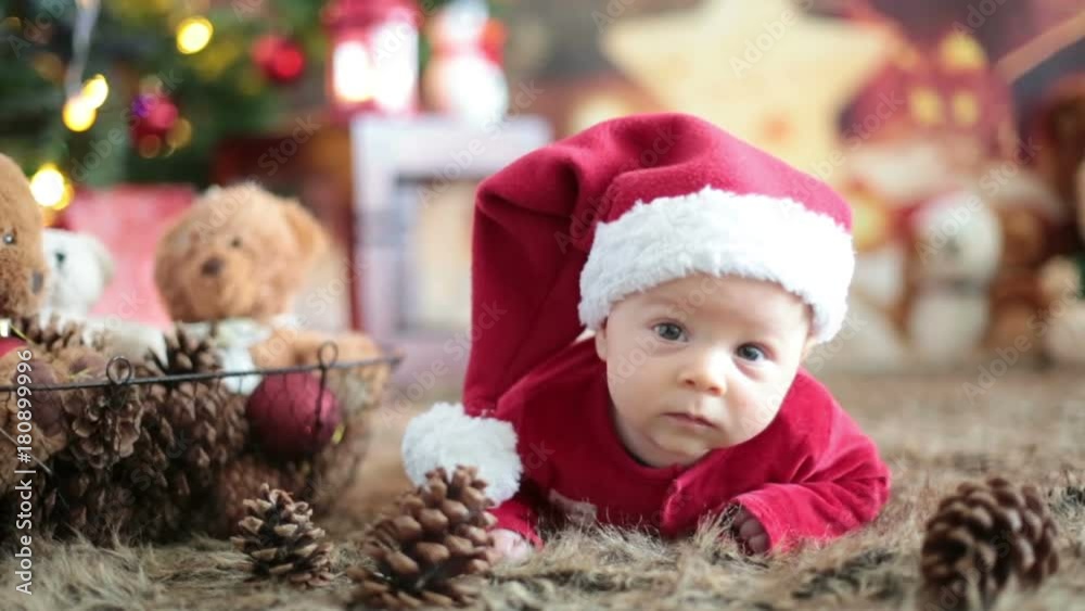 Portrait of newborn baby in Santa clothes, winter snow landscape outdoor