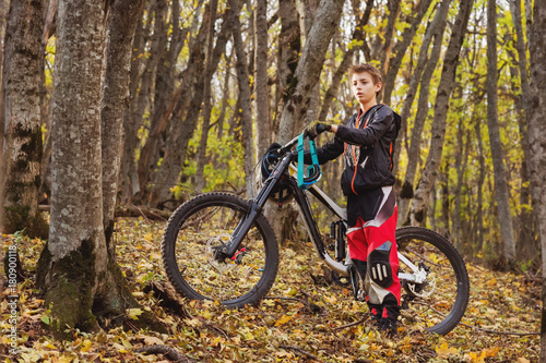 Portrait of a young rider in full protection of a full face helmet mask and gloves on a bicycle