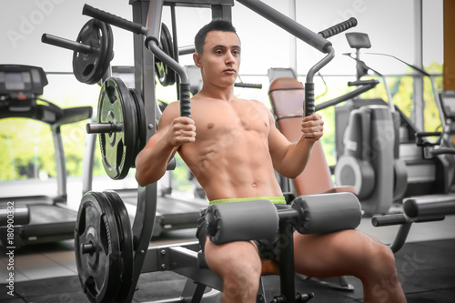Muscular man training in gym © Africa Studio