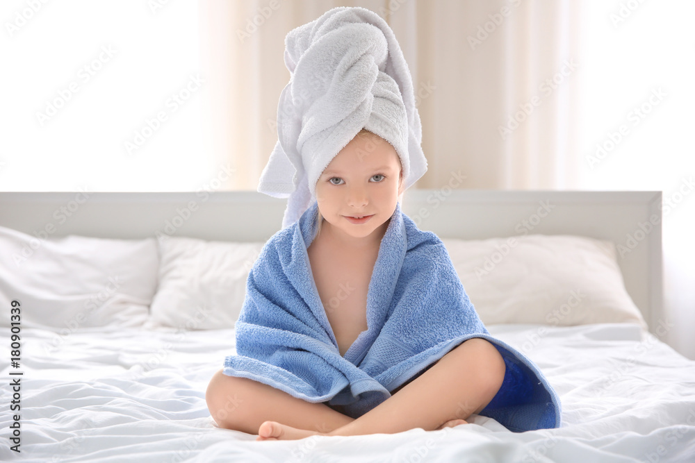 Cute little girl with towels on bed at home Cute little girl with towels on bed at home