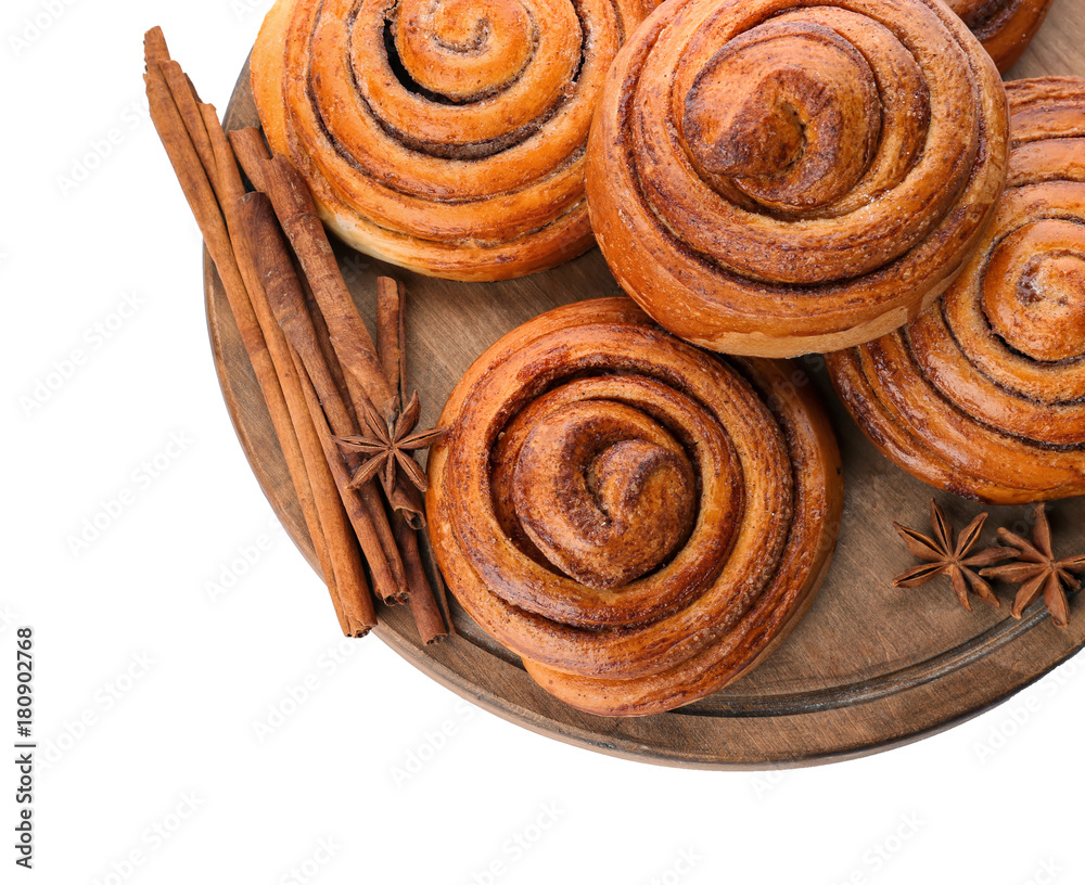 Fototapeta premium Freshly baked cinnamon rolls with aromatic cinnamon sticks and star anise on wooden board, sweet pastry dessert