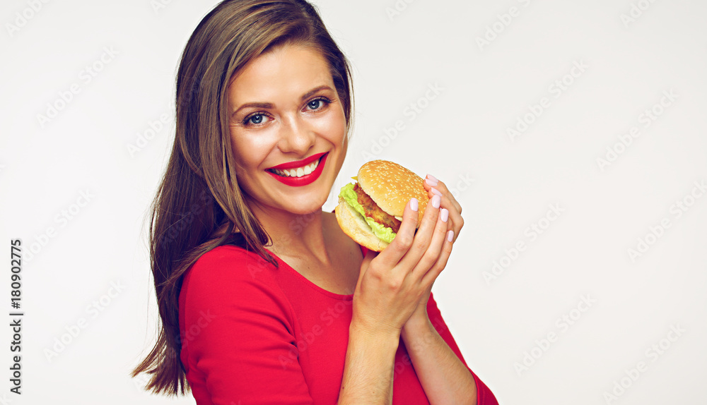Smiling woman wearing red dress holding burger. Smiling woman wearing red dress holding burger.