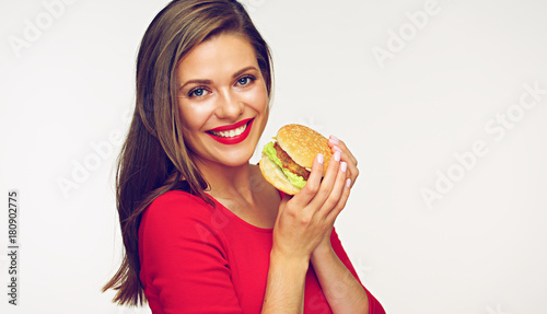 Smiling woman wearing red dress holding burger.