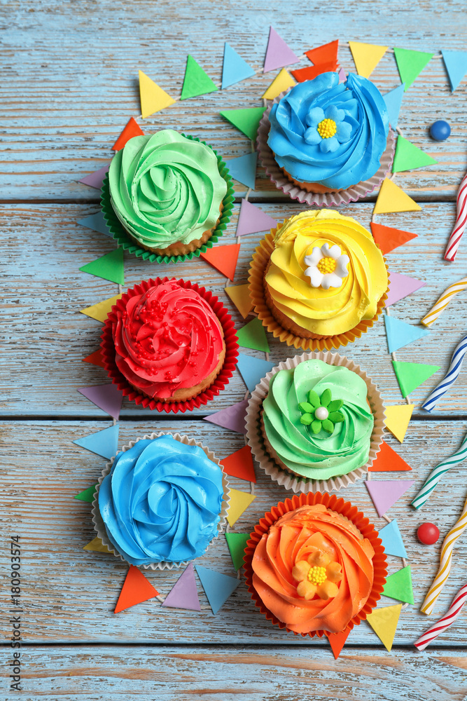 Tasty colorful cupcakes on wooden table