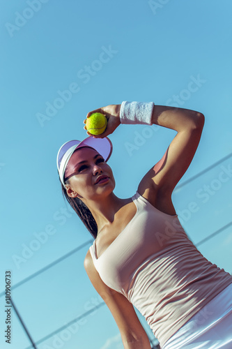 She knows how to win. Beautiful young woman holding tennis ball on the tennis court © MARIIA