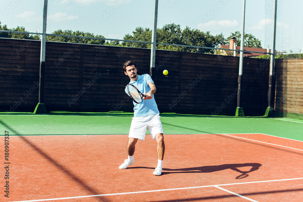 His court his rules. Full length of young handsome man playing tennis on the tennis court. 