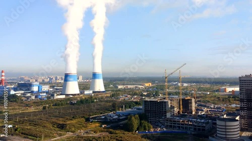 timelapse soaring tower and a view of the construction site with tower cranes and builders, stroitelstvo residential houses close to the power plant photo