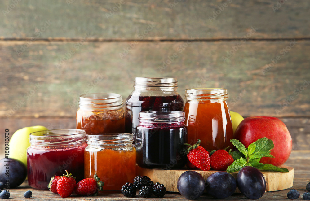Glass jars with different kinds of jam on wooden table Glass jars with different kinds of jam on wooden table