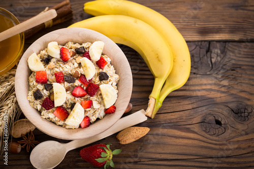 Oatmeal porridge with honey, strawberries, banana and nuts 