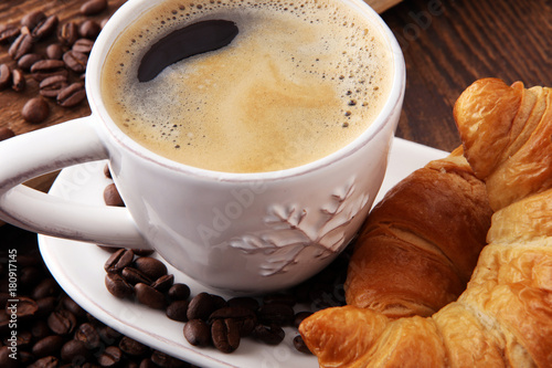 coffee and croissant with coffee beans. breakfast energy concept.