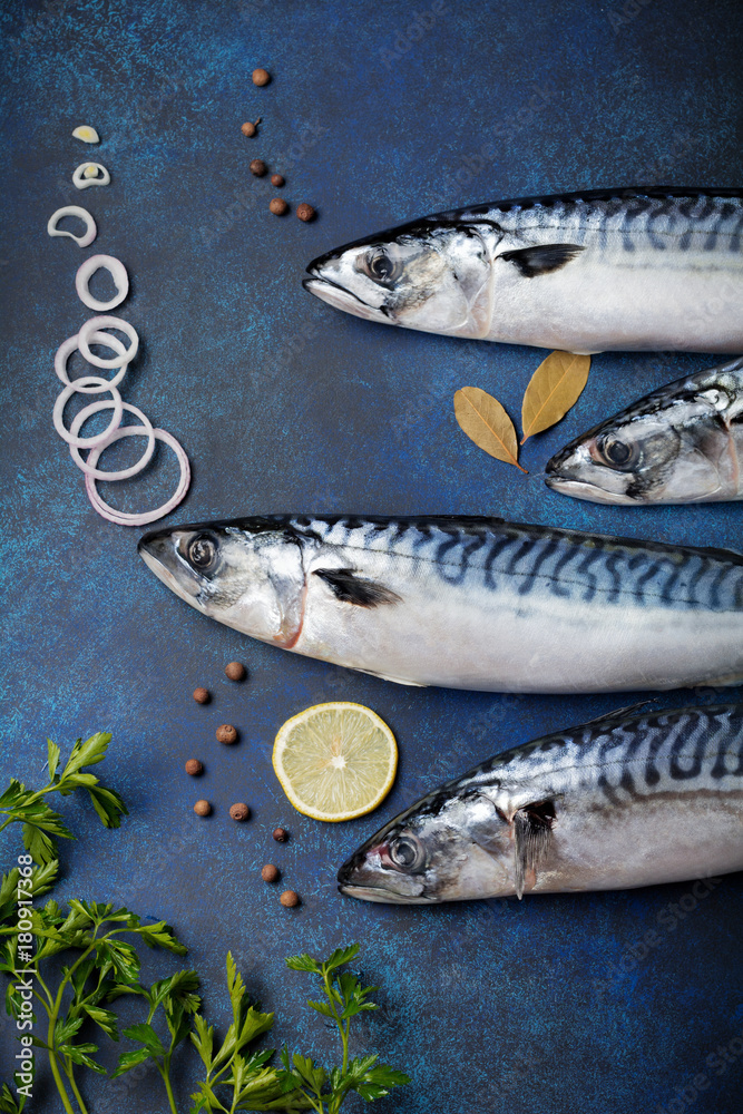 Raw mackerel fish with ingredients for cooking on a blue concrete or stone background. Selective focus. Top view. Raw mackerel fish with ingredients for cooking on a blue concrete or stone background. Selective focus. Top view.