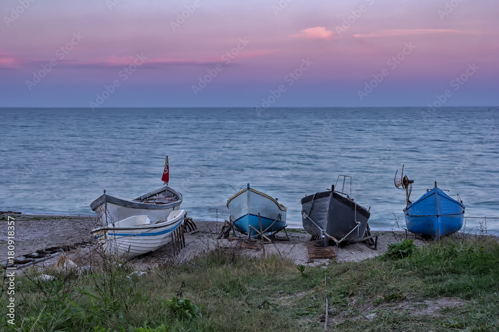 Several wooden boats on the sand, after sunset Several wooden boats on the sand, after sunset