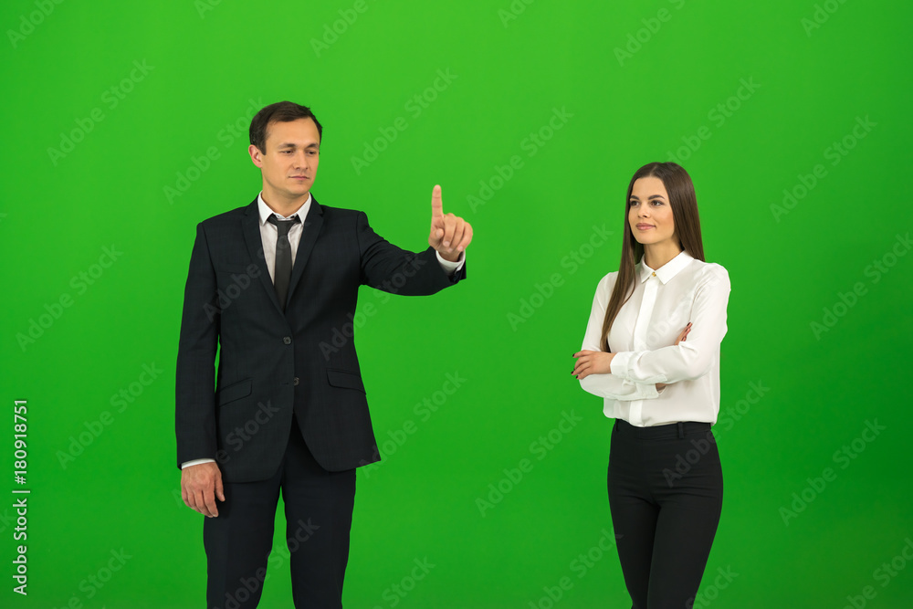 The man and woman touch the virtual screen on the green background The man and woman touch the virtual screen on the green background