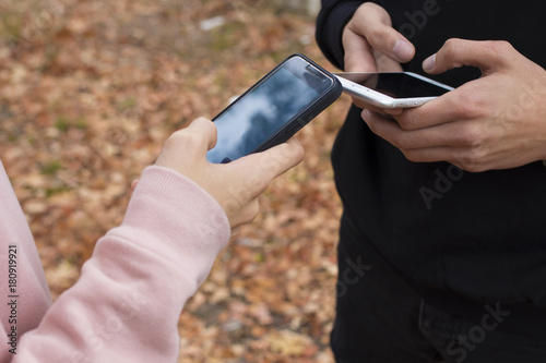 friends with a mobile phone in the fall outdoors