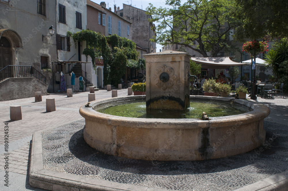 Corsica, 29/08/2017: lo skyline e i vicoli di San Fiorenzo, villaggio di pescatori sulla costa ovest dell'Alta Corsica chiamato la Saint-Tropez corsa, con vista della fontana di piazza Doria