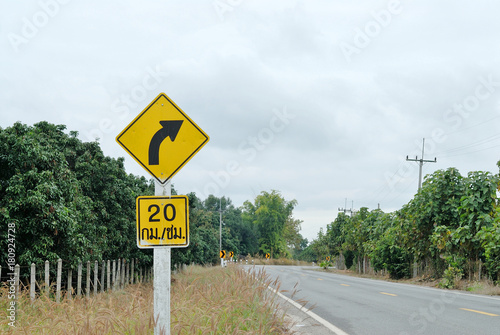 yellow traffic sign "Turn right" with speed limit board