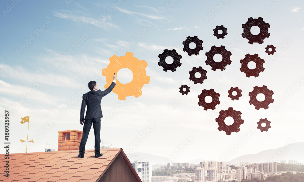 Businessman standing with back on house brick roof and drawing. Businessman standing with back on house brick roof and drawing.