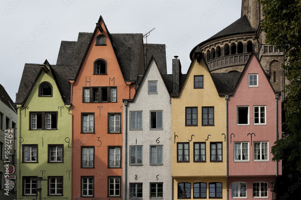 COLOGNE, GERMANY - SEPTEMBER  11, 2016: Colorful houses in Bavarian style and the Romanesque Catholic church 