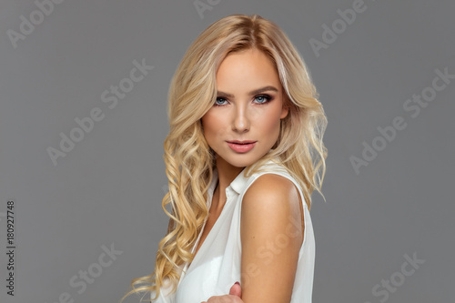 Portrait of blond beauty isolated on grey background