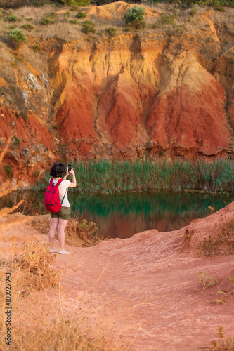 Girl taking a picture of a lake