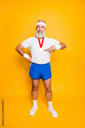 Full length of active cool funny competitive grandpa showing off his reward. Body, health, care, lifestyle, game, challenge, champ, hero, leisure, training, workout, strength, power, motivation, pride