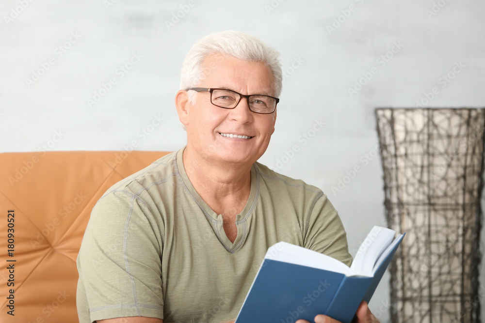 Handsome mature man reading book at home Handsome mature man reading book at home