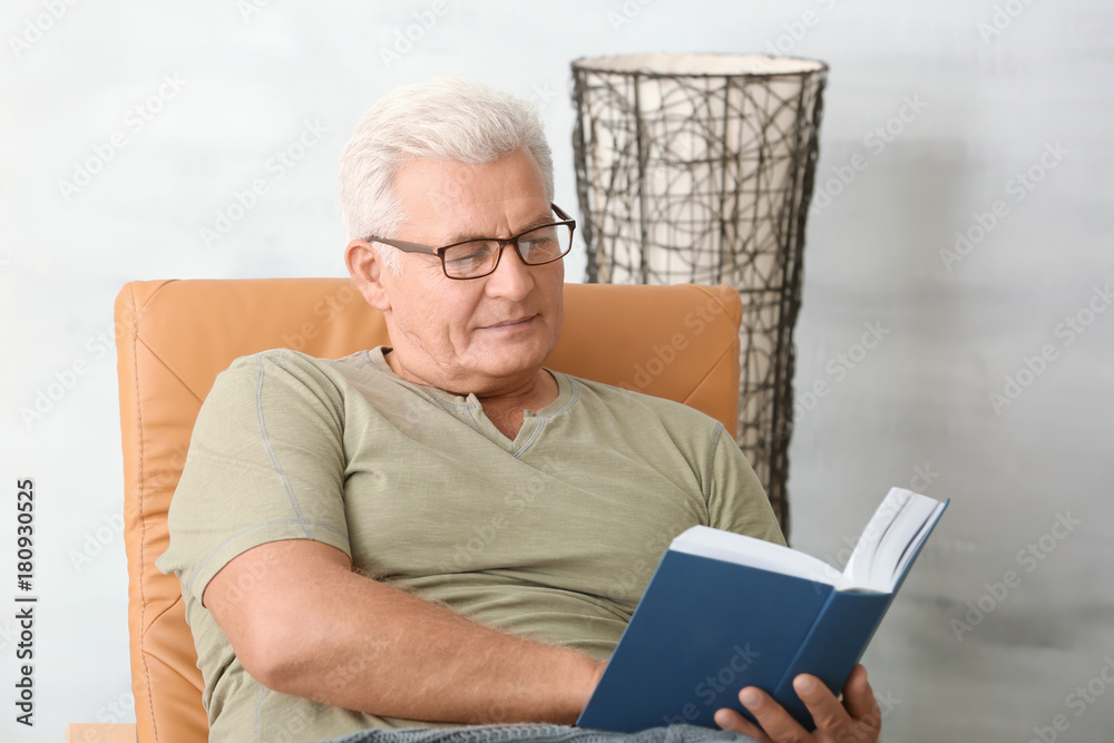 Handsome mature man reading book at home Handsome mature man reading book at home