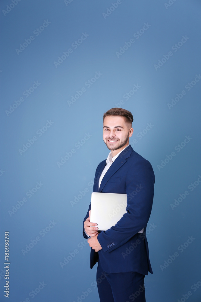 Young man with laptop against blue background Young man with laptop against blue background