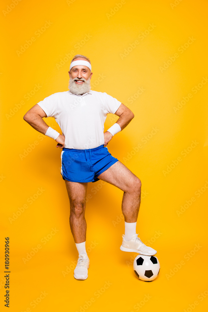 © deagreez - Full length of modern cool funny competetive pensioner, leader, champion with his foot on a ball. Bodycare, healthcare, weight loss, pride, strength, leadership, motivation, authority, gym