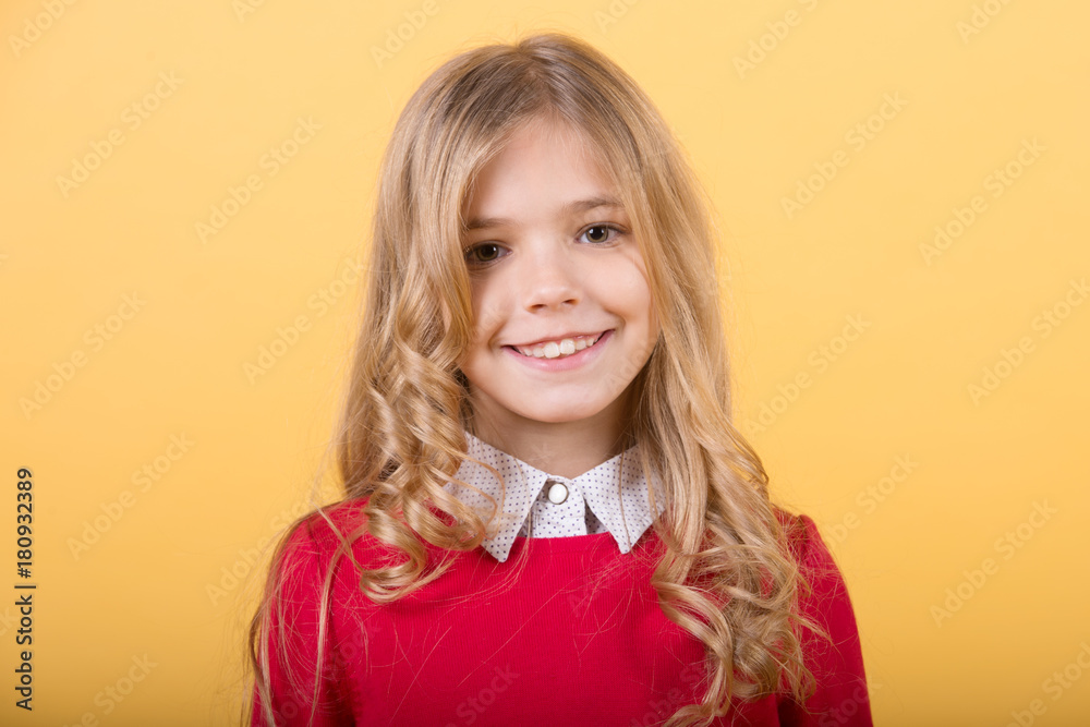 Child with curly blond hair on orange background Child with curly blond hair on orange background