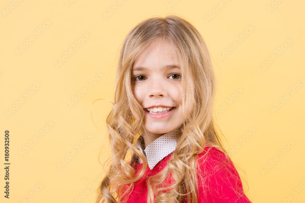 Child with curly blond hair on orange background Child with curly blond hair on orange background