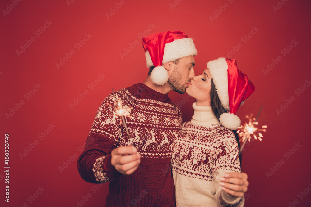 Fototapeta premium Adorable, lovely, sensual cute partners in knitted traditional x mas costumes with ornament hold sparkles and kiss, winter, noel, x mas miracle, holy spirit, true feelings