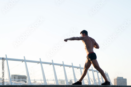 Sportsman with muscular body on white sky