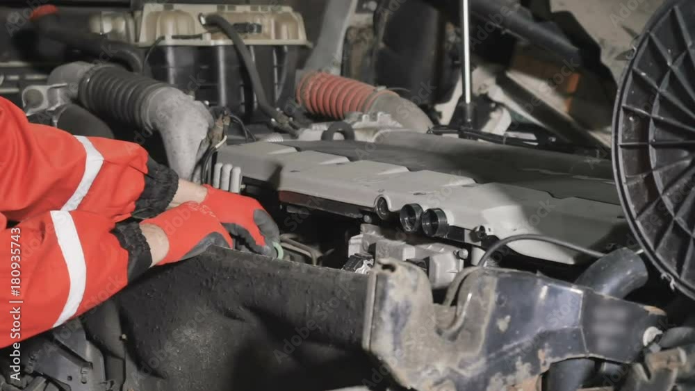 Auto mechanic checks the oil level in engine of truck