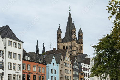 COLOGNE, GERMANY - SEPTEMBER 11, 2016: Colorful houses in Bavarian style and the Romanesque Catholic church "Gross Sankt Martin" (Great St. Martin) in the old town of Cologne, North Rhine-Westphalia