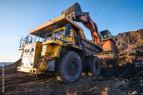 type of coal mine with working excavators and large cars

