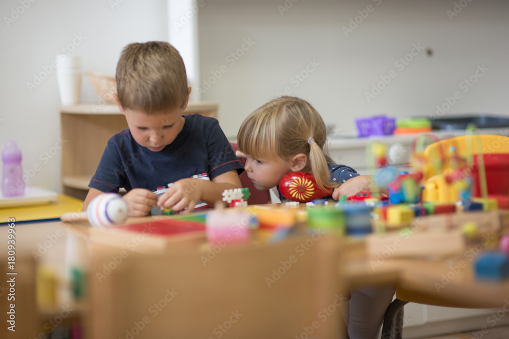 Fototapeta premium Brother and sister is playing with montessori material