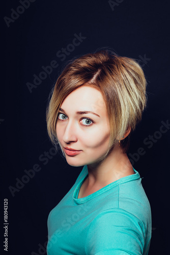 Woman with short haircut on a dark background close-up © Shadow