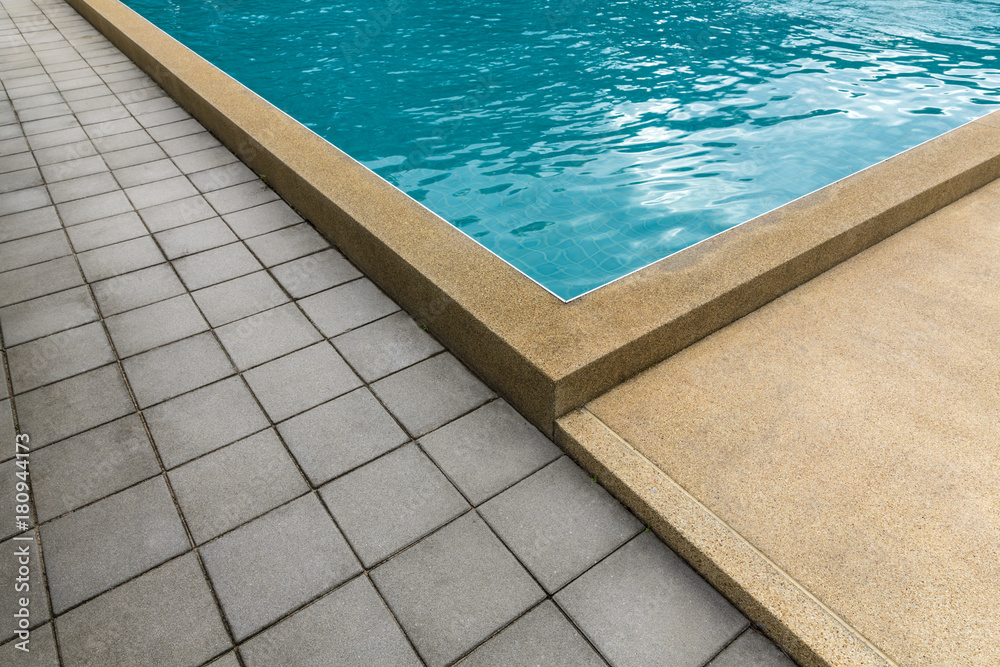 Swimming pool with cement blocks pathway and yellow polished stone floor
