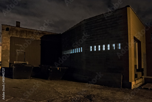 Scary dark city Chicago alley next to an urban warehouse loading dock.