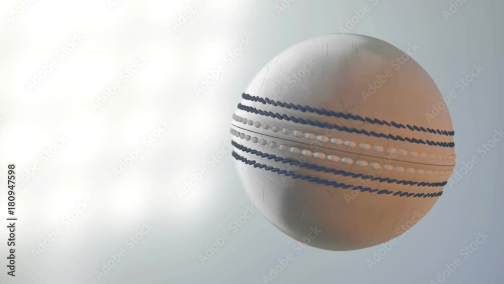 A dirty white cricket ball spinning in slow motion flying through the air on a floodlit stadium background at night A dirty white cricket ball spinning in slow motion flying through the air on a floodlit stadium background at night