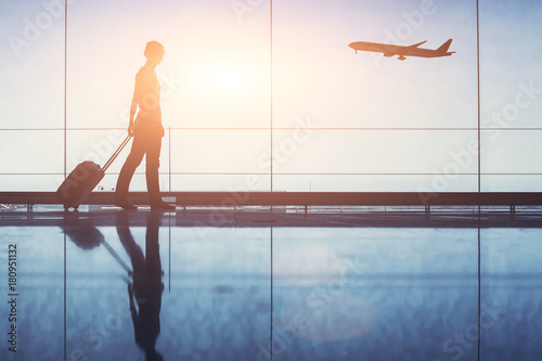 people traveling, silhouette of woman passenger with baggage in airport