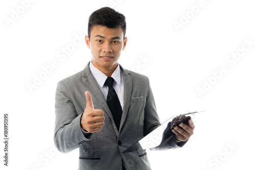 Portrait of a young business man reading annual report. Isolated on white background